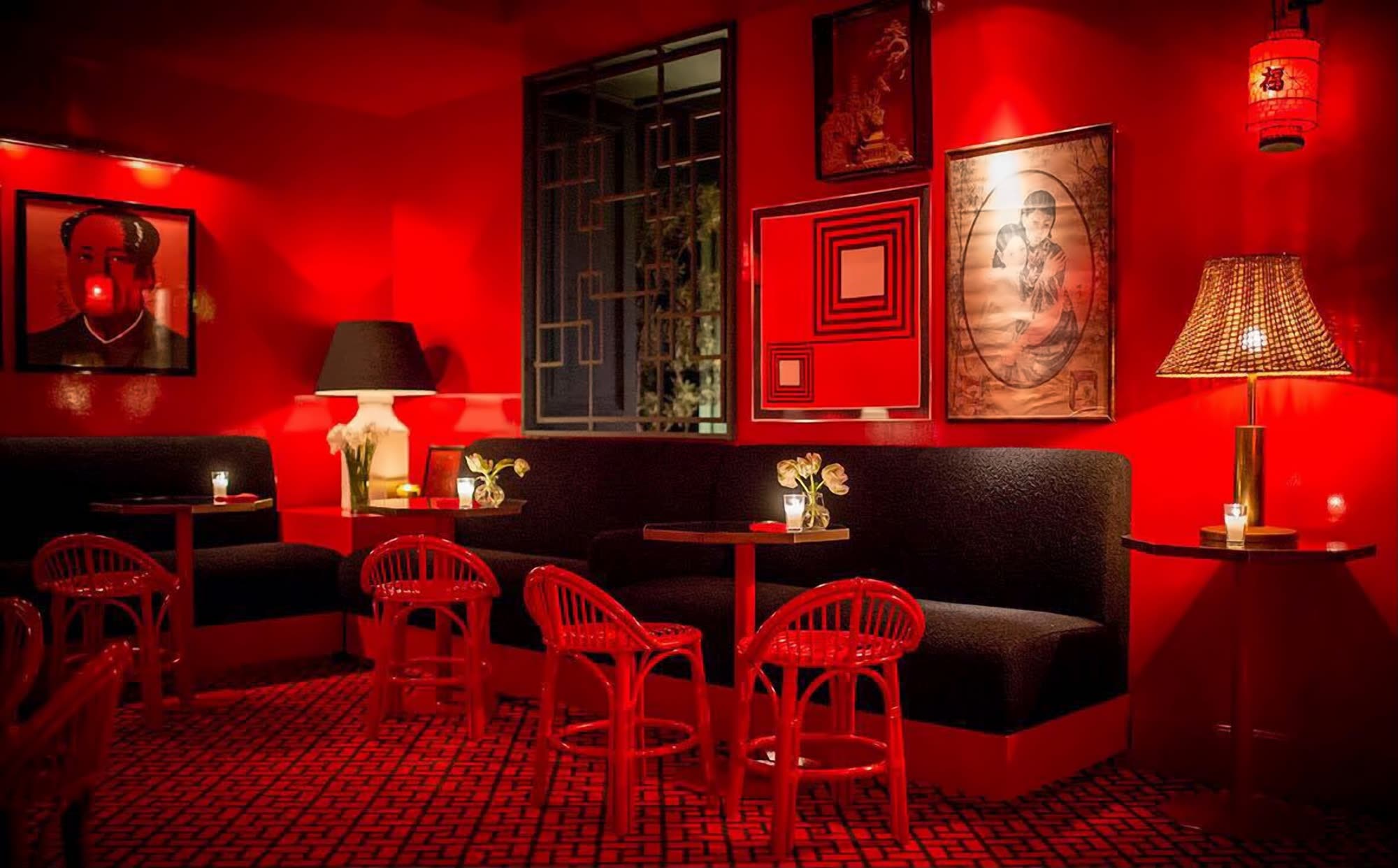 Sala Roja: paredes lacadas en rojo, sofás negros y sillas de ratán